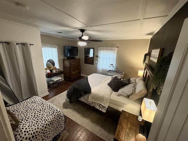 bedroom with a ceiling fan, ornamental molding, and wood finished floors