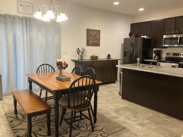 dining area with sink and an inviting chandelier