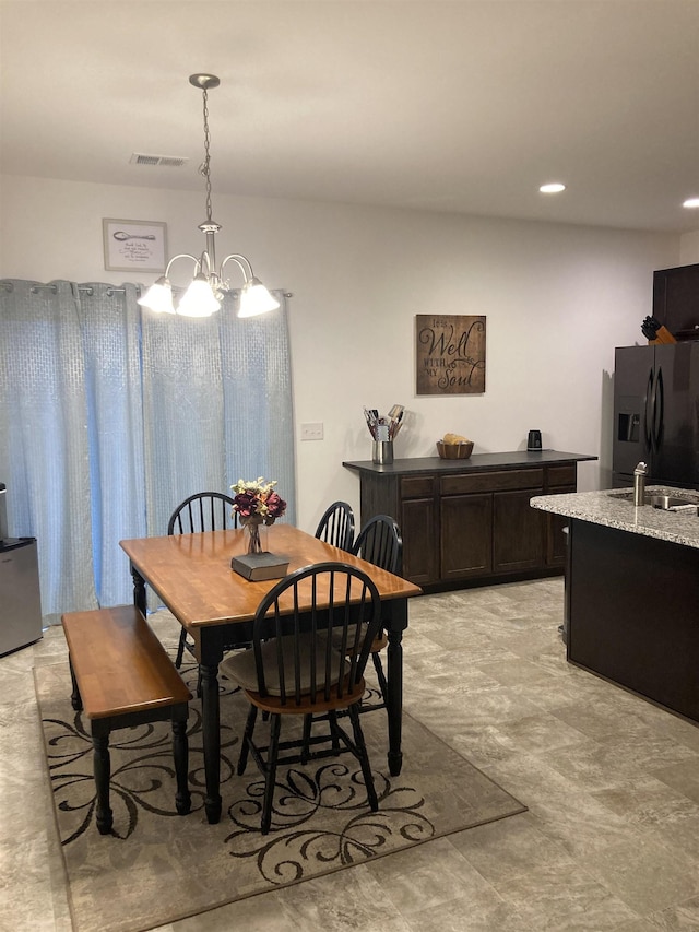 dining room featuring sink and an inviting chandelier