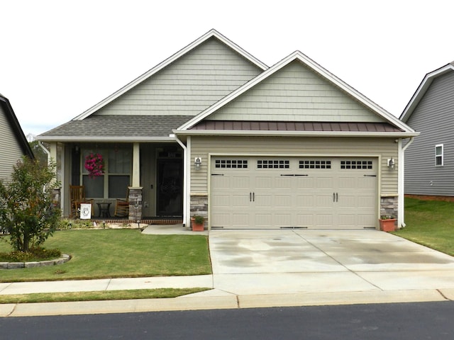 craftsman-style home featuring covered porch, a garage, and a front lawn