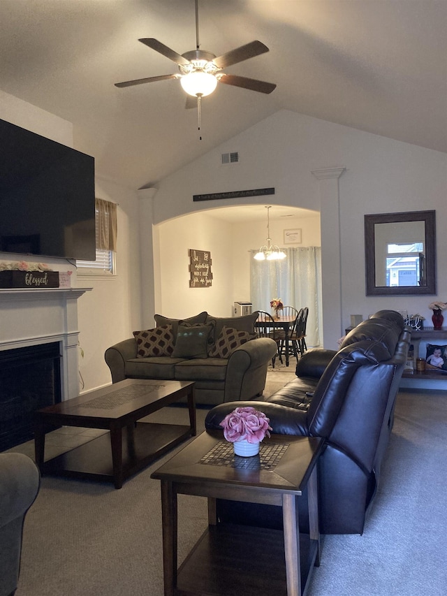 carpeted living room with ceiling fan with notable chandelier and lofted ceiling