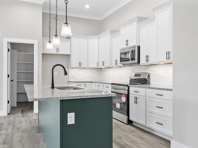 kitchen with a center island with sink, white cabinetry, sink, and appliances with stainless steel finishes