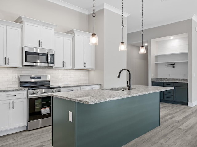 kitchen featuring appliances with stainless steel finishes, light wood-type flooring, sink, white cabinetry, and hanging light fixtures