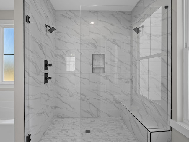 bathroom with a wealth of natural light and a shower with shower door