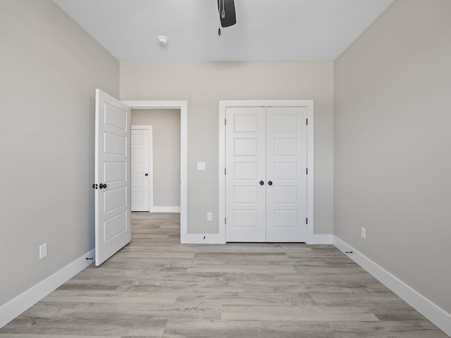 unfurnished bedroom featuring ceiling fan, a closet, and light hardwood / wood-style floors