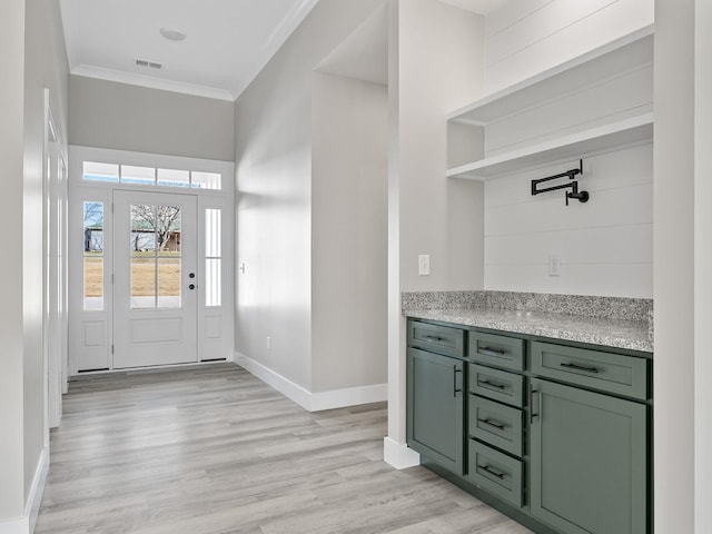 entrance foyer featuring ornamental molding and light wood-type flooring