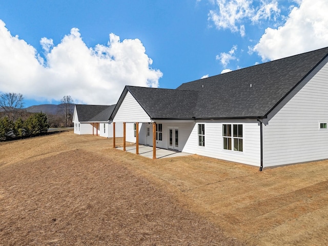 back of property featuring a lawn, a patio area, and a mountain view