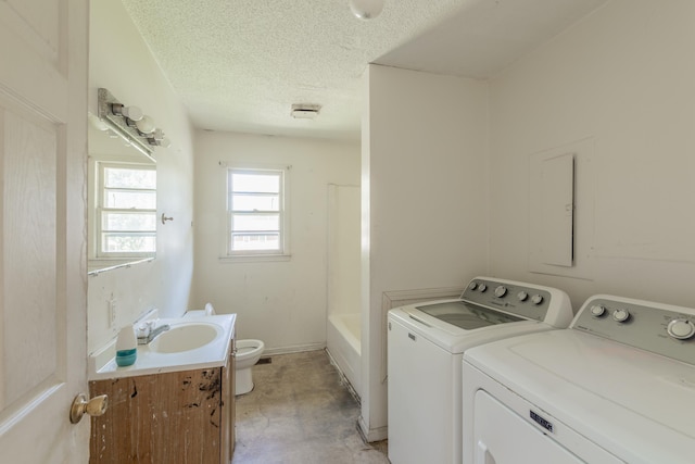 washroom with separate washer and dryer, sink, and a textured ceiling