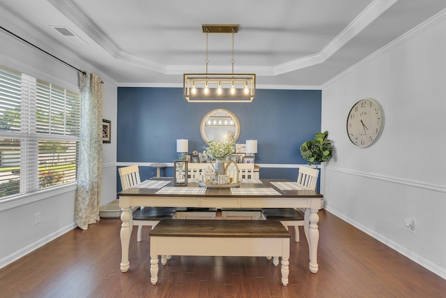 dining area with dark hardwood / wood-style flooring, a raised ceiling, and ornamental molding