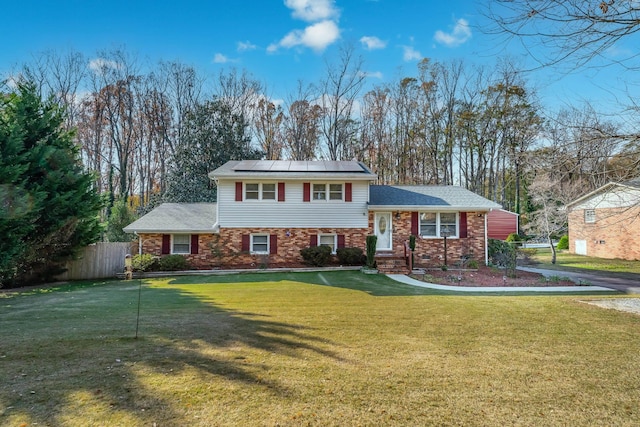 split level home featuring a front yard and solar panels