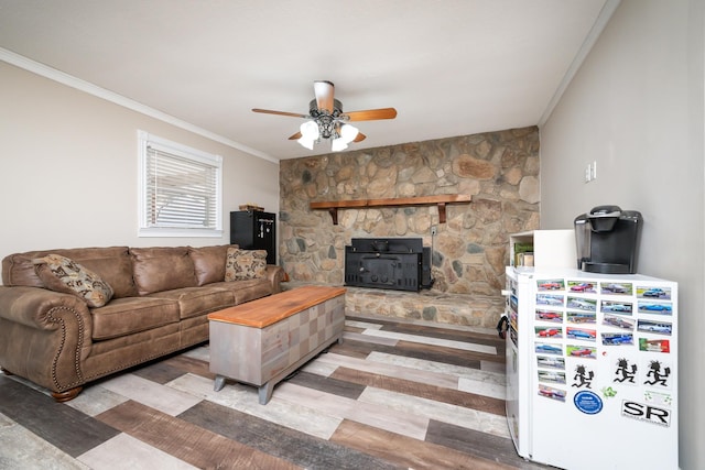 living room featuring crown molding, ceiling fan, light hardwood / wood-style floors, and a wood stove