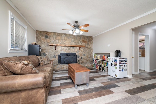 living room featuring plenty of natural light, ornamental molding, ceiling fan, and a wood stove