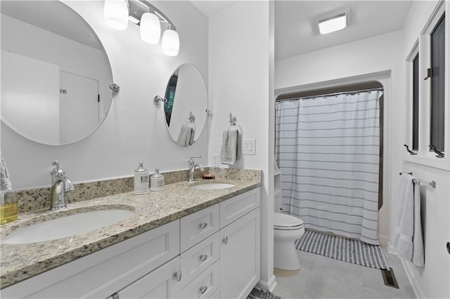 bathroom featuring tile patterned floors, vanity, a shower with shower curtain, and toilet