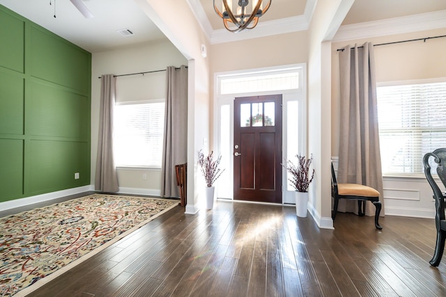 entrance foyer with a healthy amount of sunlight, crown molding, and dark wood-type flooring