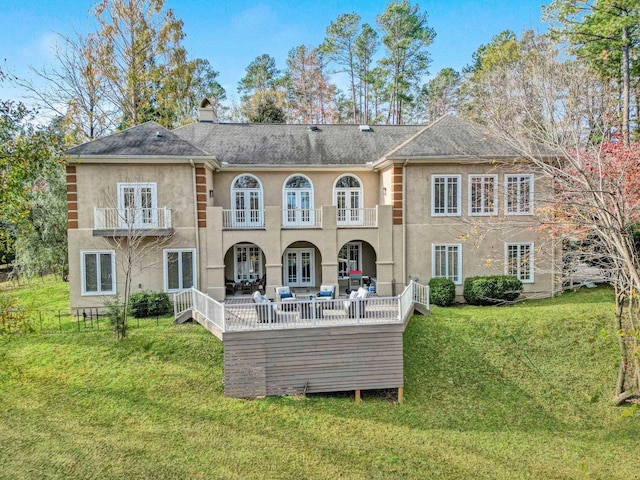 back of house with an outdoor living space, a patio area, a balcony, and a yard