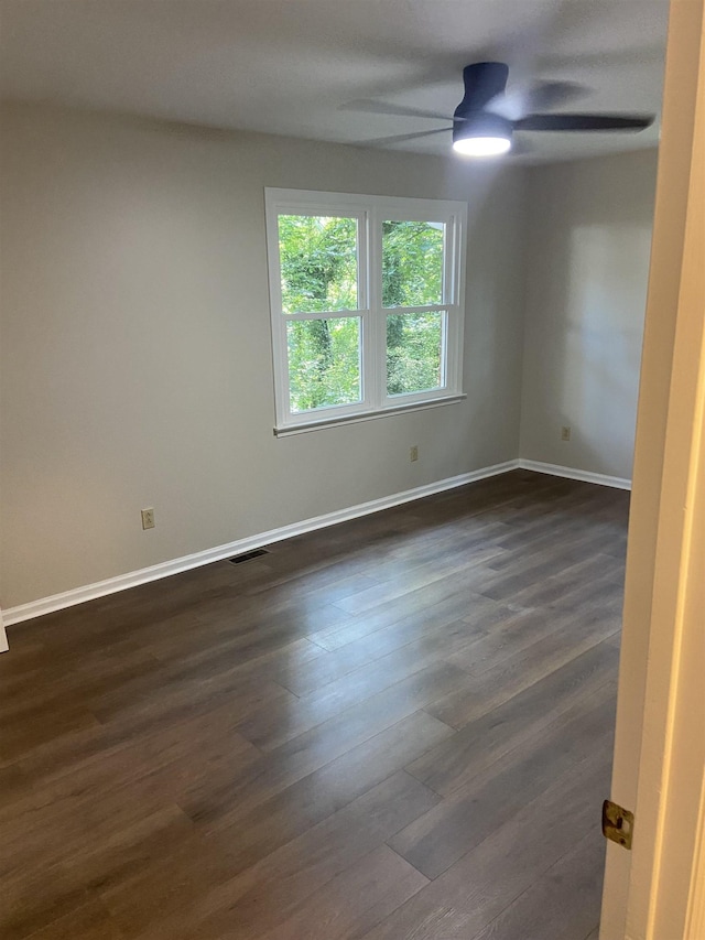 empty room featuring ceiling fan and dark wood-type flooring