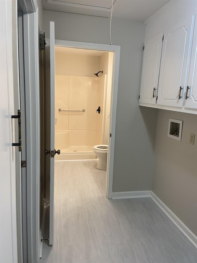 bathroom with hardwood / wood-style flooring, toilet, and a shower