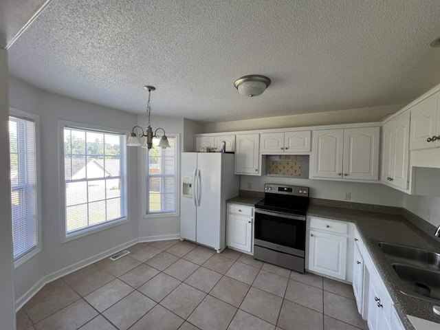 kitchen with sink, white refrigerator with ice dispenser, pendant lighting, white cabinets, and stainless steel electric range