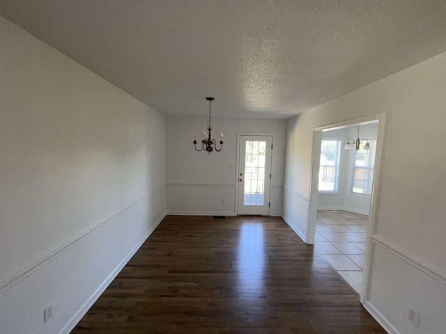 entrance foyer with a textured ceiling, dark hardwood / wood-style floors, and a notable chandelier