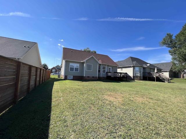 back of property featuring a wooden deck and a yard