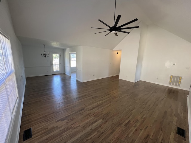 unfurnished living room with ceiling fan with notable chandelier, dark hardwood / wood-style floors, and high vaulted ceiling