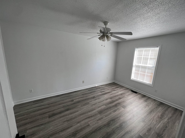 spare room featuring a textured ceiling, dark hardwood / wood-style floors, and ceiling fan