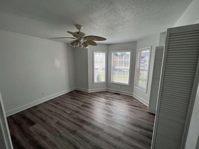 spare room featuring ceiling fan, dark hardwood / wood-style flooring, and a textured ceiling