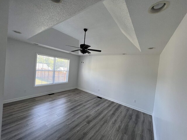 empty room featuring dark hardwood / wood-style floors, ceiling fan, lofted ceiling, and a textured ceiling