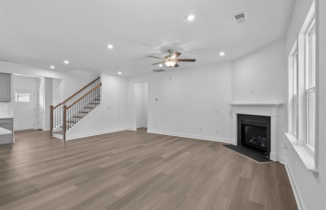 unfurnished living room with light hardwood / wood-style floors and ceiling fan