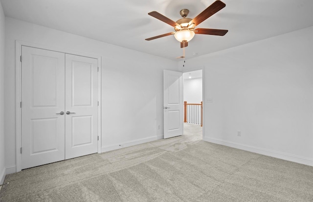 unfurnished bedroom with ceiling fan, a closet, and light carpet