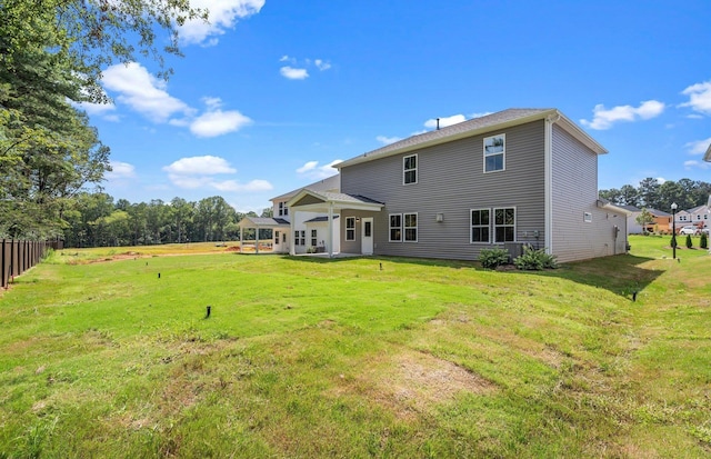 back of property featuring a patio area and a lawn