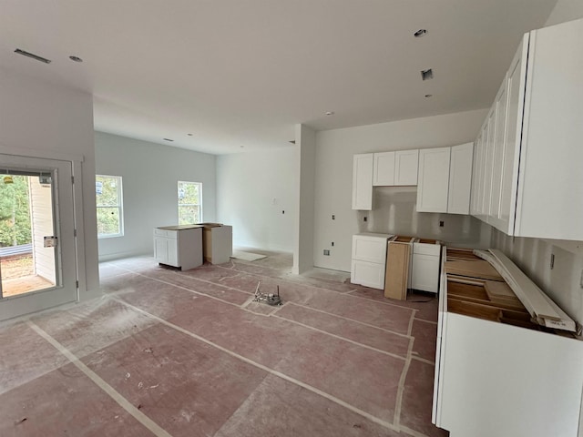 kitchen with a wealth of natural light, a center island, and white cabinets