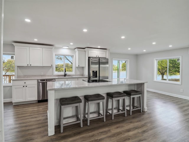 kitchen with white cabinets, appliances with stainless steel finishes, and a wealth of natural light