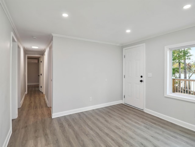 spare room featuring ornamental molding and light hardwood / wood-style flooring