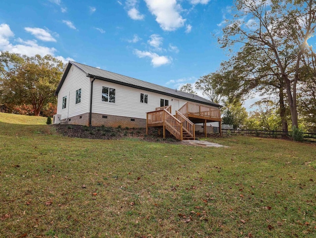 rear view of house with a yard and a deck