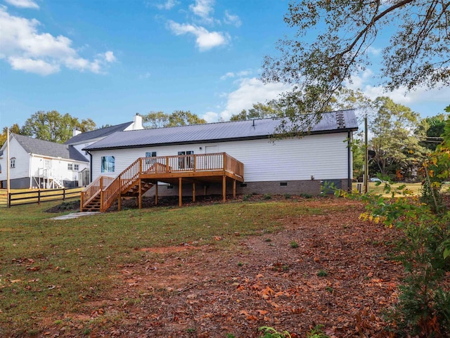 back of house featuring a deck and a lawn