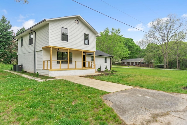 view of front of house featuring covered porch, cooling unit, and a front yard