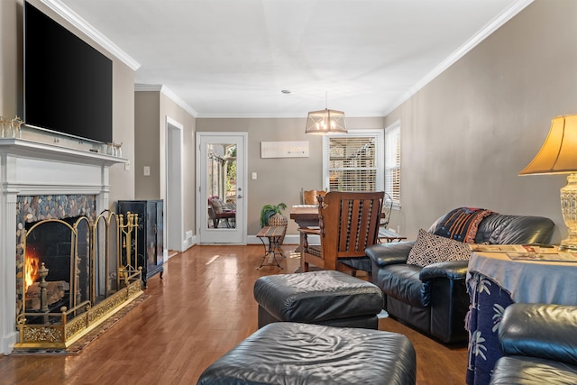 living room featuring dark hardwood / wood-style flooring, an inviting chandelier, and ornamental molding