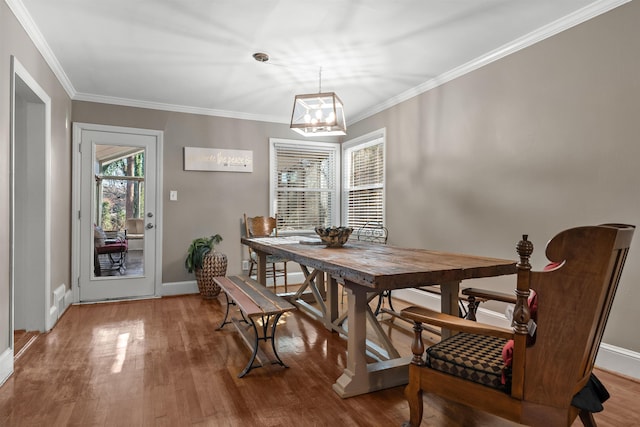 dining space featuring wood-type flooring and ornamental molding