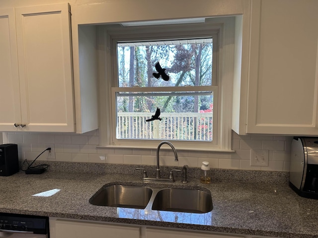 kitchen with dishwasher, backsplash, white cabinets, sink, and dark stone countertops