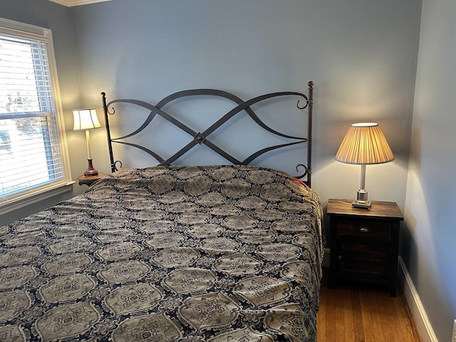 bedroom with dark hardwood / wood-style floors and crown molding