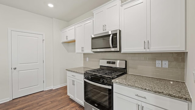 kitchen featuring light stone countertops, appliances with stainless steel finishes, tasteful backsplash, dark hardwood / wood-style floors, and white cabinetry