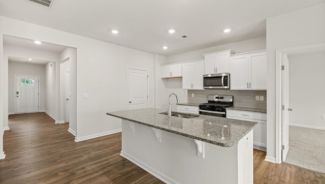 kitchen with white cabinetry, sink, a kitchen island with sink, appliances with stainless steel finishes, and hardwood / wood-style flooring