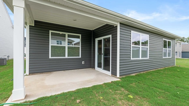 rear view of property with a yard and central air condition unit