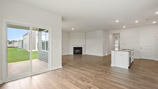 unfurnished living room featuring dark hardwood / wood-style flooring and sink