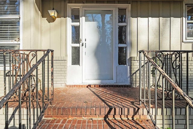 doorway to property featuring brick siding