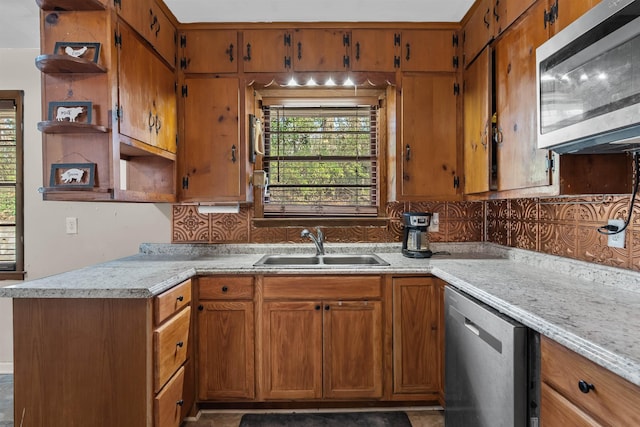 kitchen with appliances with stainless steel finishes, a sink, light countertops, open shelves, and backsplash