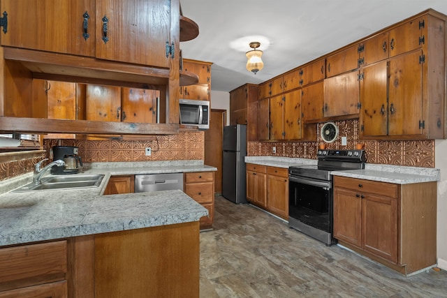 kitchen with decorative backsplash, appliances with stainless steel finishes, kitchen peninsula, and sink