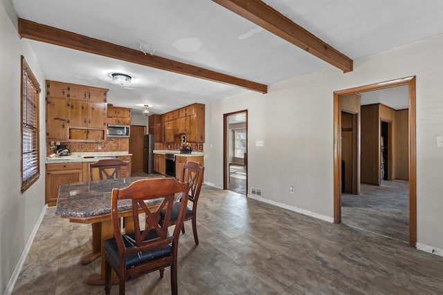 dining room featuring beamed ceiling and sink