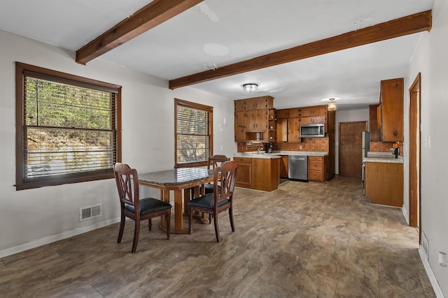 dining area with visible vents, beamed ceiling, and baseboards